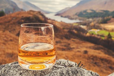 Glass of single malt Scotch Whisky on an old rock above Glenfinnan in the West Highlands of Scotland.