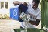 Man Emptying Household Recycling Into Green Bin Getty