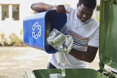 Man Emptying Household Recycling Into Green Bin Getty